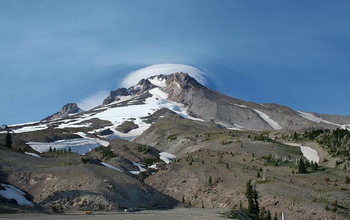 view of a mountain peak with patches of snow